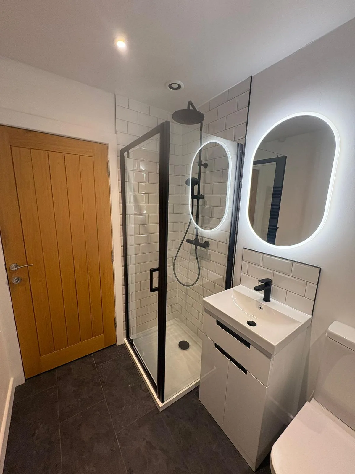 Bathroom with walk-in shower, wall-hung basin and illuminated mirror